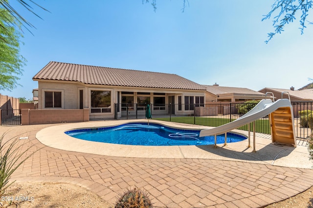 view of swimming pool featuring a patio and a water slide