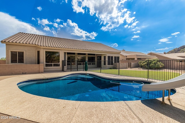 view of pool featuring a fenced in pool, a patio, fence, a water slide, and a yard