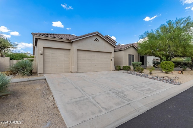 view of front of house with a garage, a tiled roof, driveway, and stucco siding