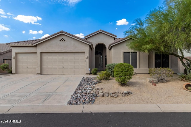 view of front of house with driveway, an attached garage, a tile roof, and stucco siding