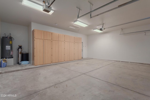 garage with a garage door opener and electric water heater