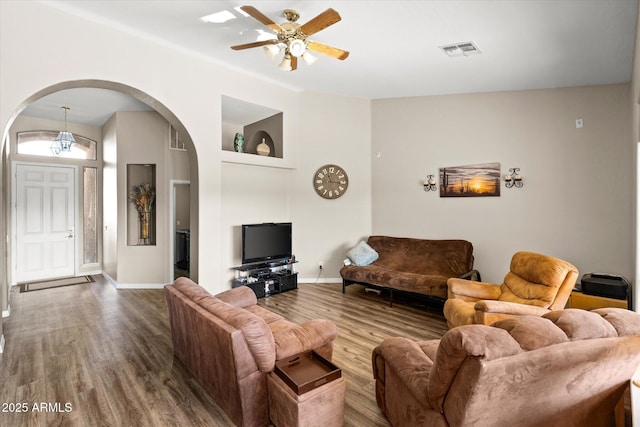 living room featuring hardwood / wood-style flooring, ceiling fan, and built in shelves