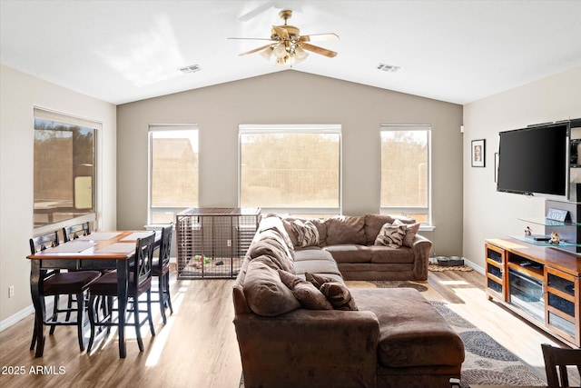 living room with a wealth of natural light, ceiling fan, light hardwood / wood-style flooring, and lofted ceiling