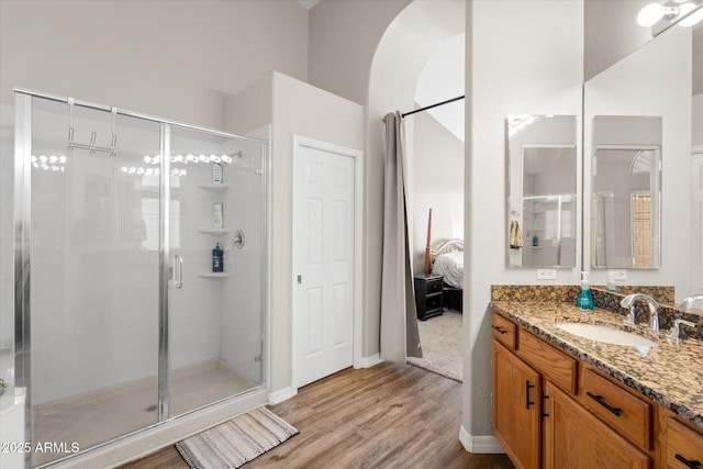 bathroom with hardwood / wood-style floors, walk in shower, and vanity