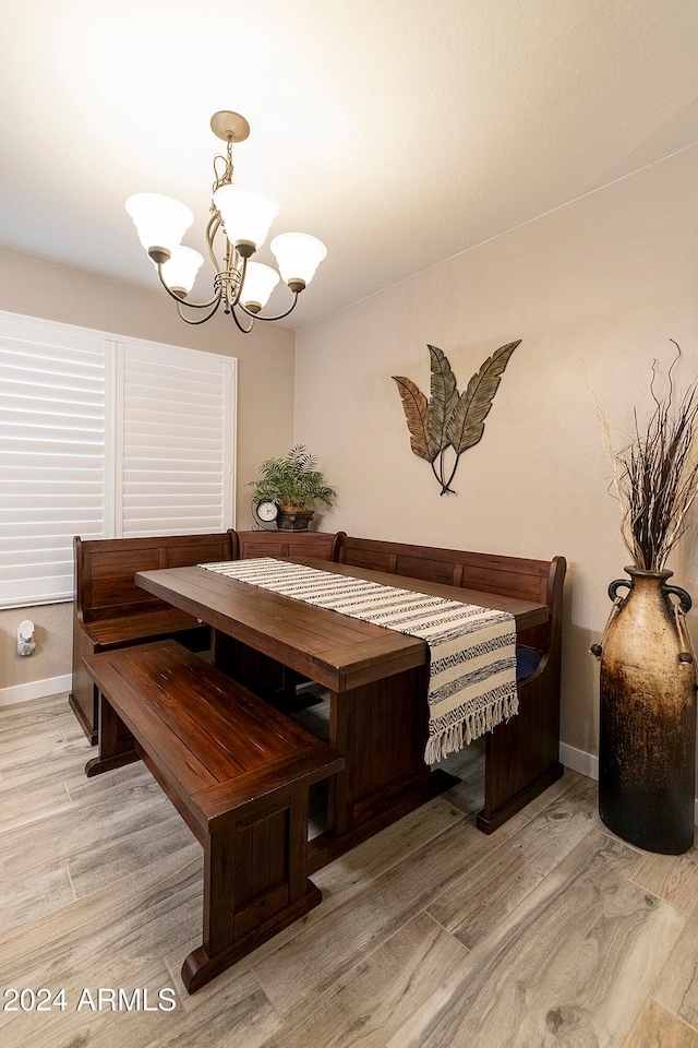 dining area featuring breakfast area, an inviting chandelier, and light wood-type flooring