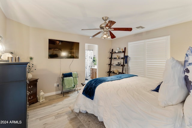 bedroom with light hardwood / wood-style floors, ensuite bathroom, and ceiling fan