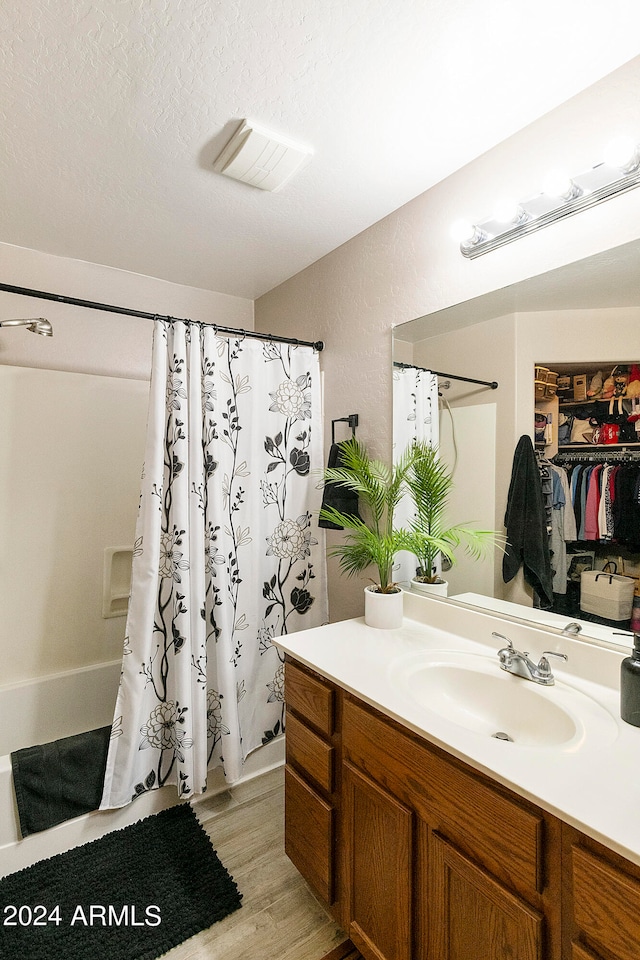 bathroom featuring vanity, a textured ceiling, hardwood / wood-style flooring, and a shower with curtain