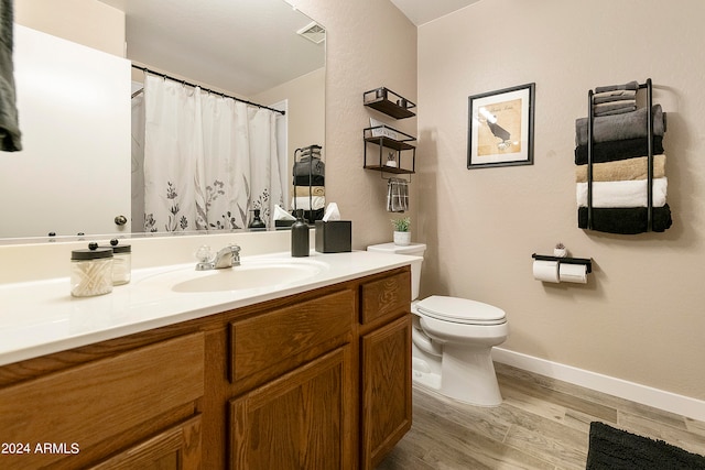 bathroom with vanity, toilet, and hardwood / wood-style flooring