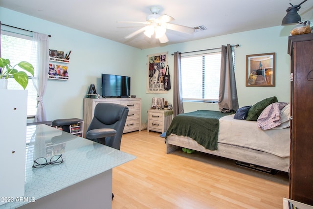 bedroom featuring multiple windows, light hardwood / wood-style flooring, and ceiling fan