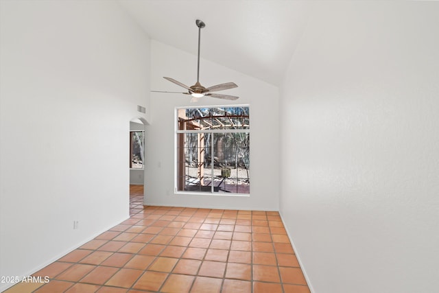 empty room featuring light tile patterned floors, baseboards, arched walkways, a ceiling fan, and vaulted ceiling