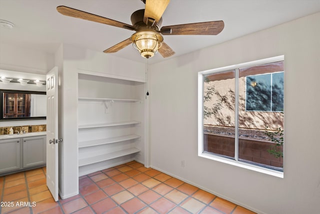 unfurnished bedroom with light tile patterned floors, a closet, a sink, and ceiling fan