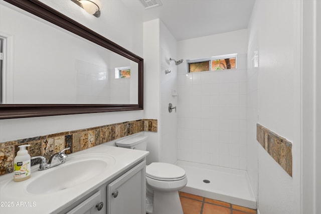 bathroom with a tile shower, visible vents, toilet, and tile patterned flooring