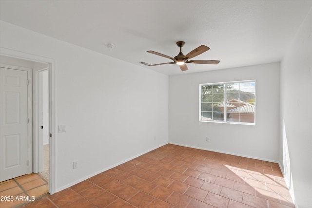 tiled spare room with visible vents, baseboards, and a ceiling fan