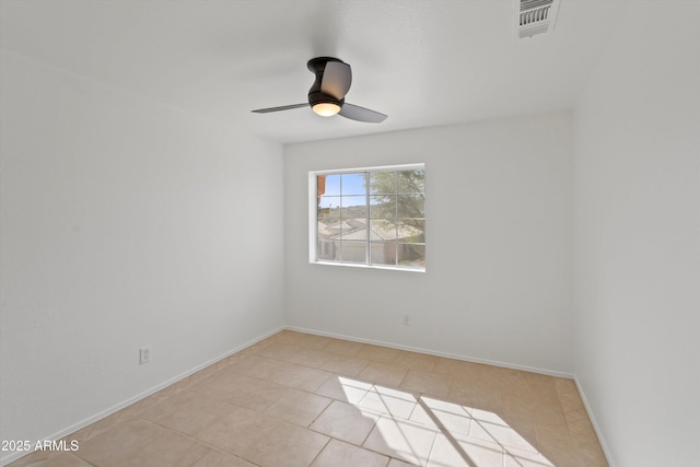 empty room with light tile patterned flooring, baseboards, a ceiling fan, and visible vents