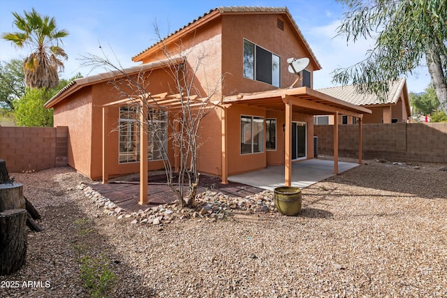 rear view of property with a patio area, a fenced backyard, a tiled roof, and stucco siding