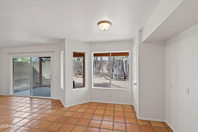 empty room with baseboards and tile patterned flooring