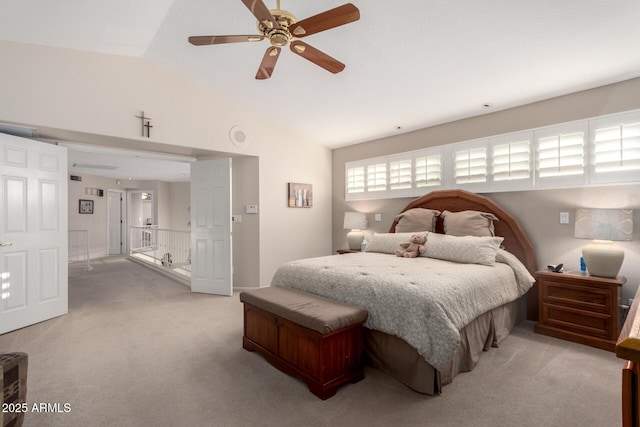bedroom featuring light colored carpet, vaulted ceiling, and ceiling fan