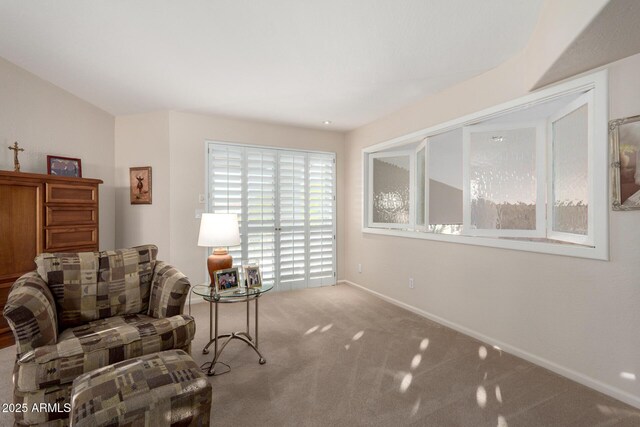 living area featuring carpet flooring and baseboards
