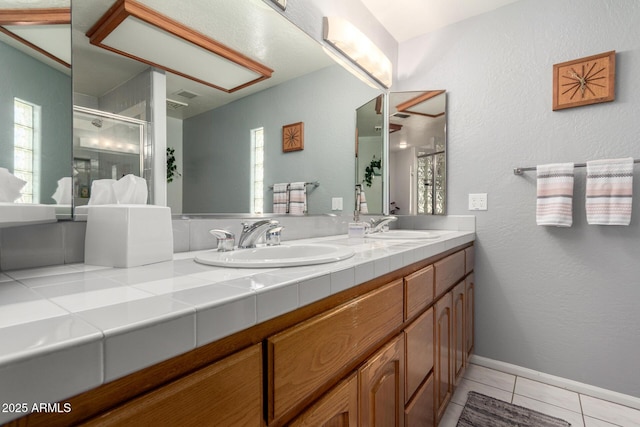 full bathroom with tile patterned flooring, a shower stall, double vanity, and plenty of natural light
