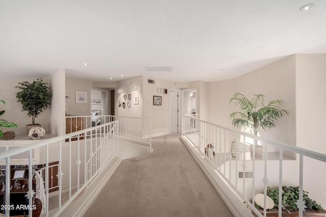 corridor with an upstairs landing, light carpet, recessed lighting, and baseboards