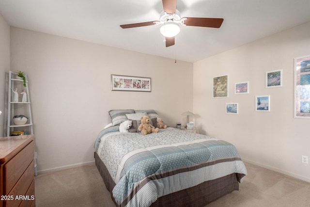 bedroom featuring light colored carpet, baseboards, and ceiling fan