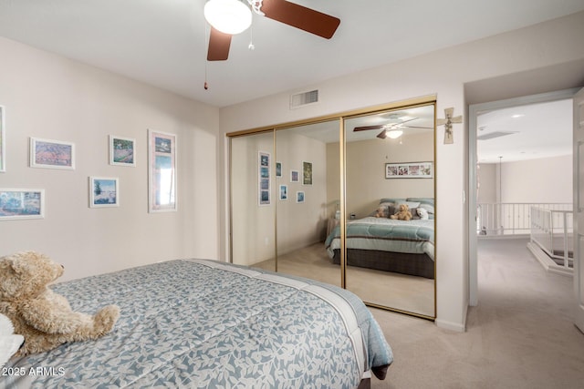 bedroom featuring light carpet, a ceiling fan, and a closet