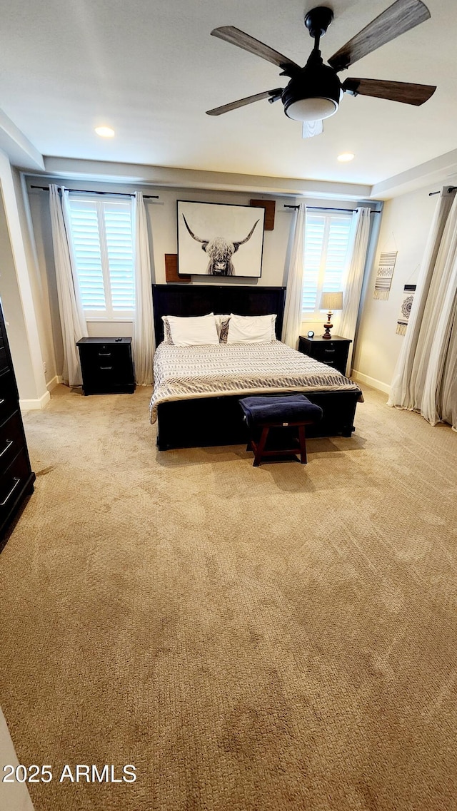 carpeted bedroom with ceiling fan and multiple windows