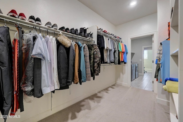 spacious closet featuring light carpet and washing machine and clothes dryer