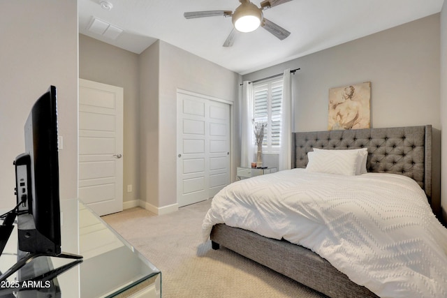 bedroom featuring a closet, light colored carpet, and ceiling fan