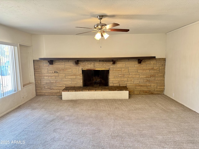 unfurnished living room with ceiling fan, a fireplace, carpet flooring, and a textured ceiling