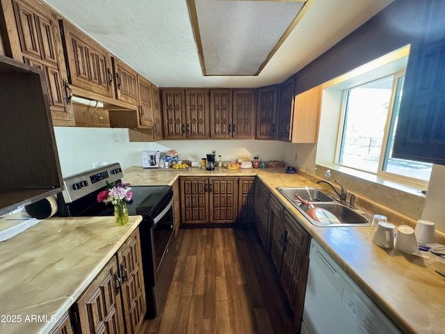 kitchen featuring sink, dark hardwood / wood-style flooring, electric range, white dishwasher, and a textured ceiling