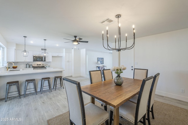 dining room featuring light wood-style flooring, baseboards, visible vents, recessed lighting, and ceiling fan with notable chandelier