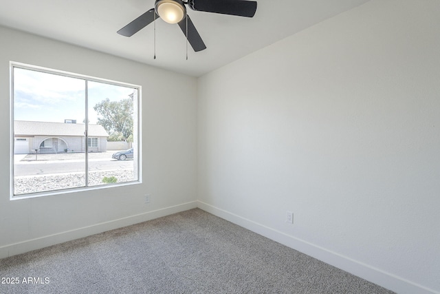 spare room with baseboards, carpet floors, and ceiling fan