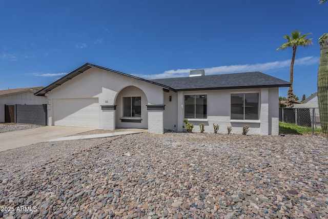 ranch-style house featuring fence, roof with shingles, driveway, and a garage