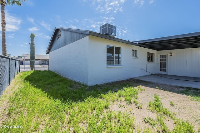 back of house with brick siding, a patio area, central AC unit, and fence