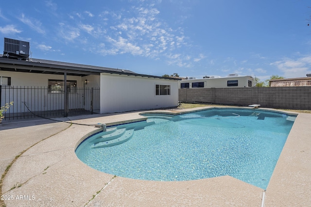 view of pool with a fenced backyard, central AC unit, a patio, and a fenced in pool