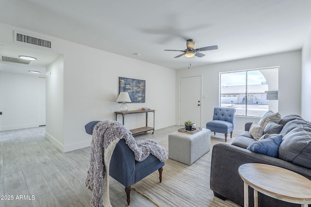 living area with wood finished floors, visible vents, baseboards, and ceiling fan