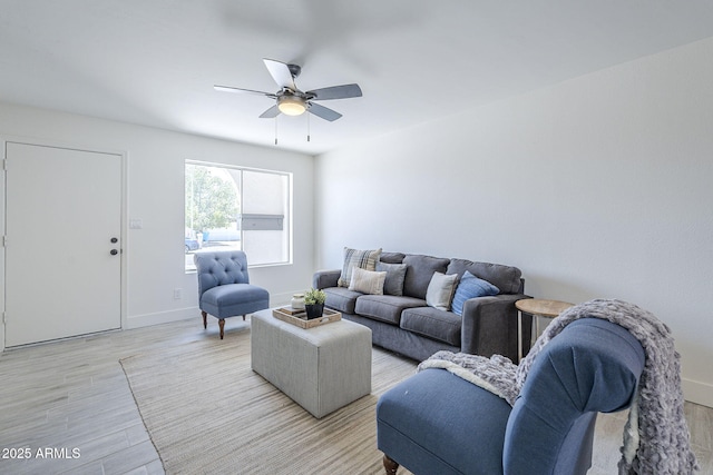 living area with light wood-style flooring, baseboards, and ceiling fan
