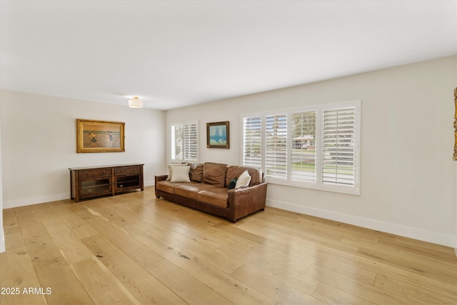 living area featuring light wood finished floors and baseboards