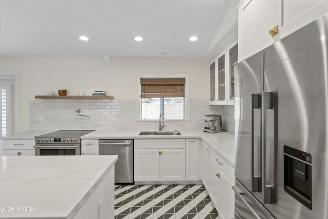 kitchen featuring stainless steel appliances, glass insert cabinets, white cabinets, and a sink