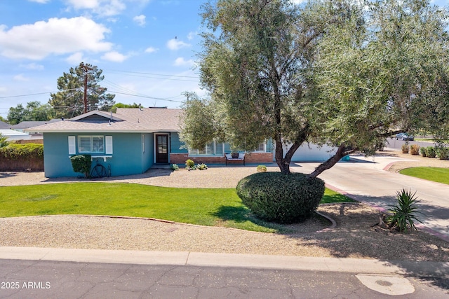 ranch-style home featuring brick siding, a shingled roof, driveway, and a front lawn