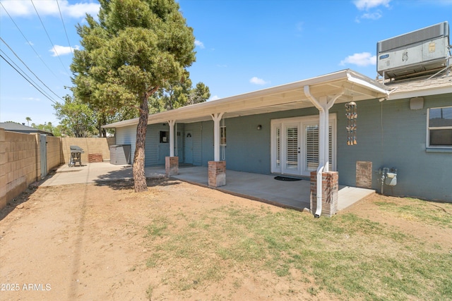 rear view of house with a patio, french doors, central AC unit, and fence