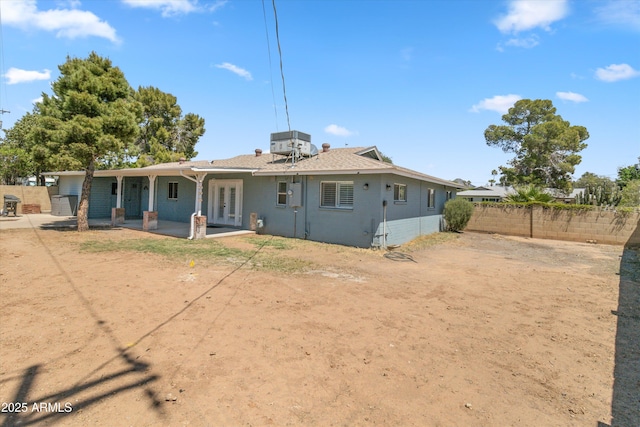 back of property featuring a patio area, french doors, fence, and central AC