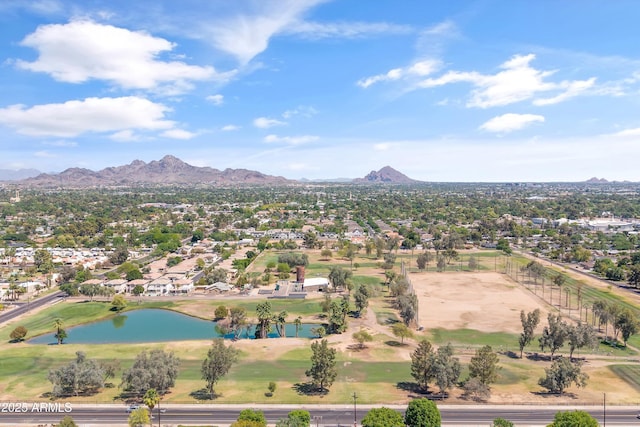 drone / aerial view featuring golf course view, a water and mountain view, and a residential view