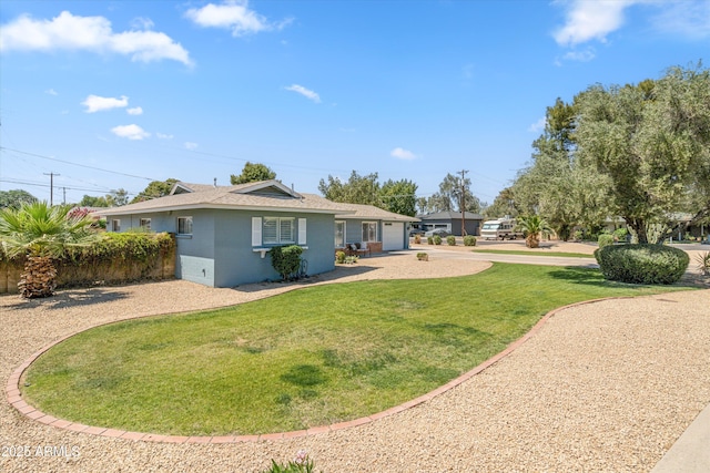 rear view of property featuring an attached garage, a lawn, driveway, and roof with shingles