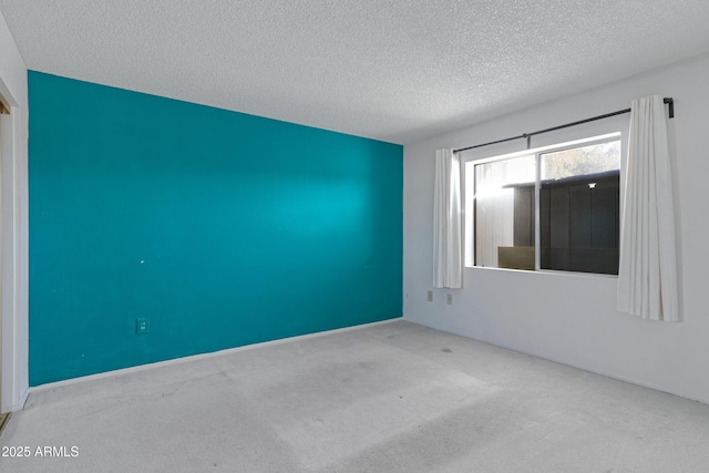 empty room featuring light carpet and a textured ceiling