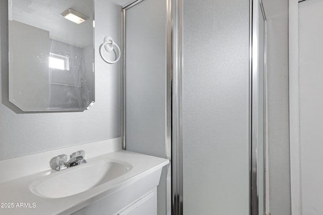 bathroom featuring vanity and a shower with door