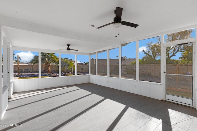 unfurnished sunroom with ceiling fan