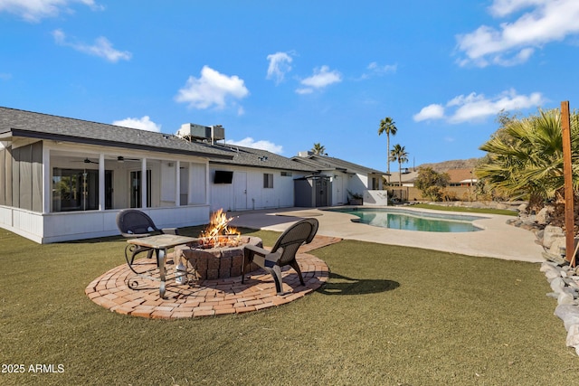 rear view of house featuring a fire pit, a lawn, ceiling fan, cooling unit, and a patio area