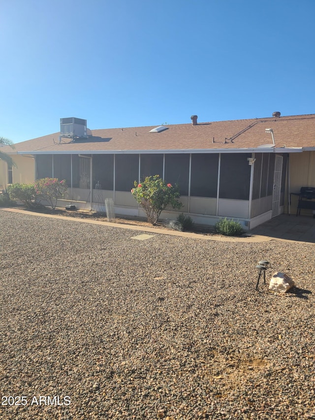 rear view of property featuring a sunroom and central air condition unit